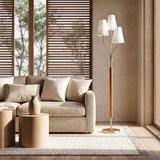Gold three-head floor lamp with linen shades and rubberwood handle, shown in a living room setting