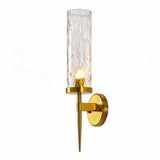 Gold wall sconce with water ripple glass shade, shown at an angle