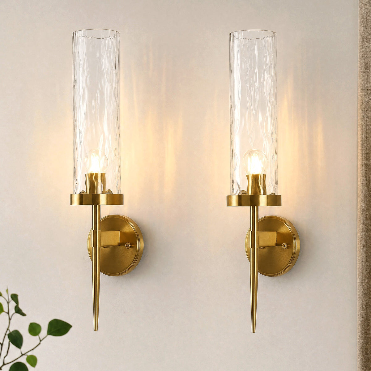 Two gold wall sconces with water ripple glass shades mounted on a wall