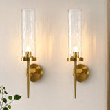 Two gold wall sconces with water ripple glass shades mounted on a wall