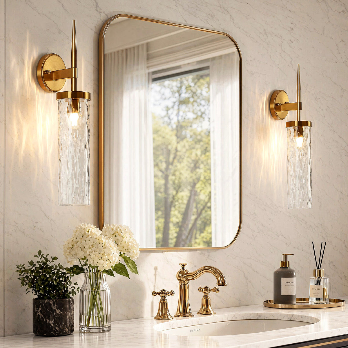 Two gold wall sconces with water ripple glass shades mounted on marble wall above bathroom sink