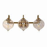 Three-light gold bathroom vanity light with clear pumpkin-shaped glass shades, shown from front