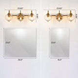 Gold bathroom vanity light with three pumpkin glass shades, 23.62" wide, shown above two mirror sizes