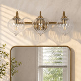 Gold bathroom vanity light with three pumpkin-shaped glass shades above a mirror