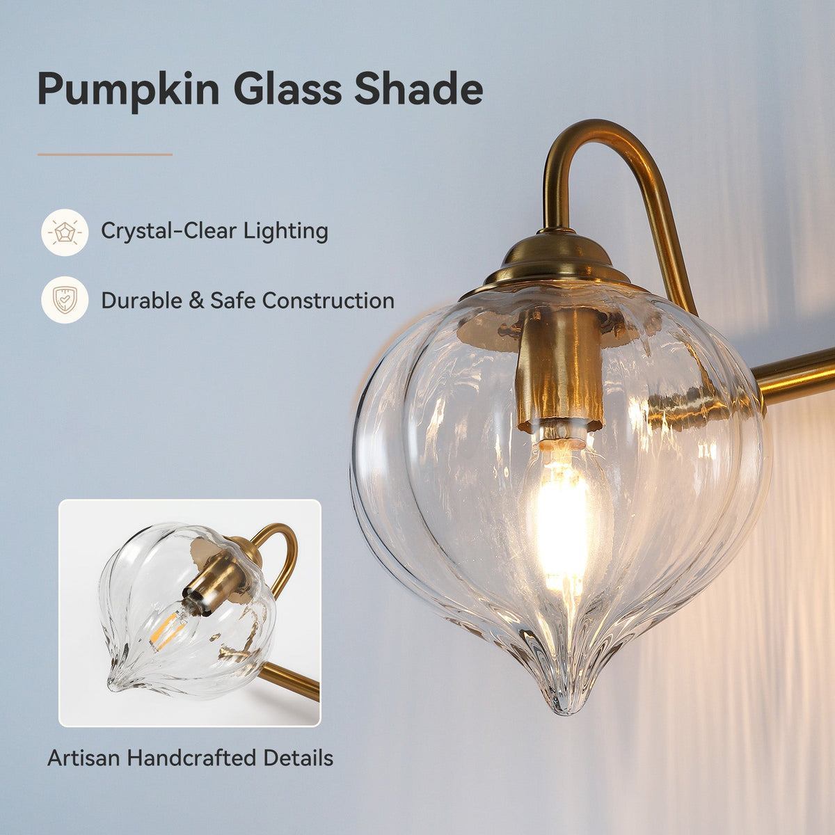 Gold bathroom vanity light with three pumpkin glass shades, shown at an angle