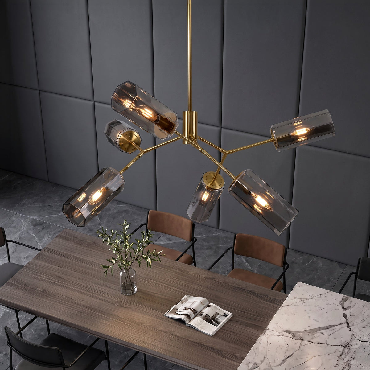 Gold branch chandelier with six smoky gray glass shades hanging over a dining table