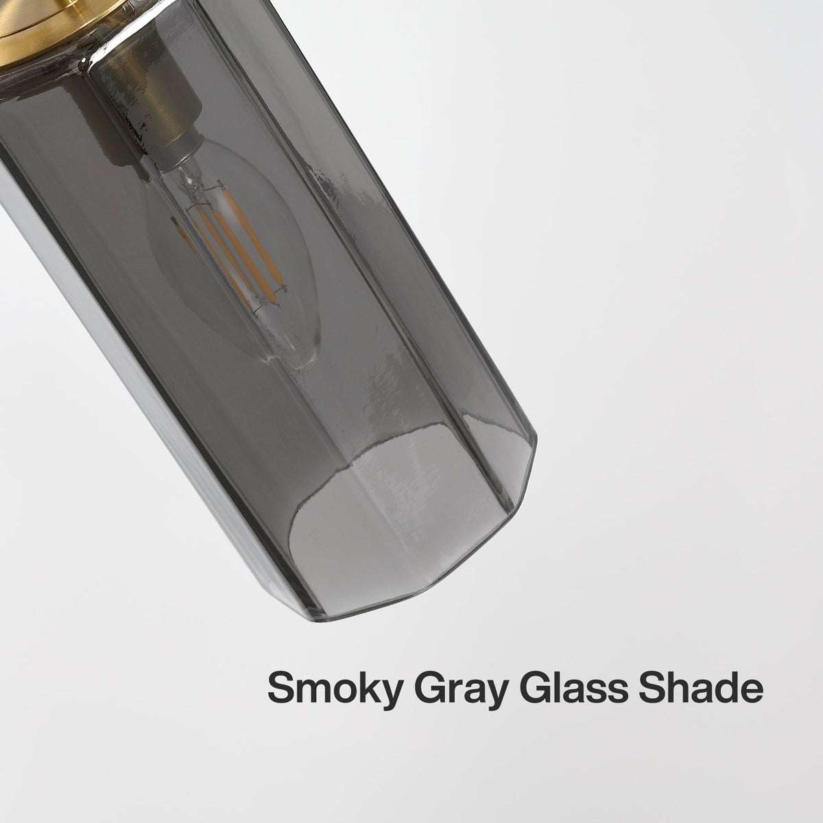 Close-up of a smoky gray glass shade on a gold chandelier, angled view
