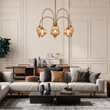 Antique brass chandelier with mercury glass shades hanging over a modern living room sofa