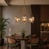 Antique brass chandelier with mercury glass shades hanging over a wooden dining table