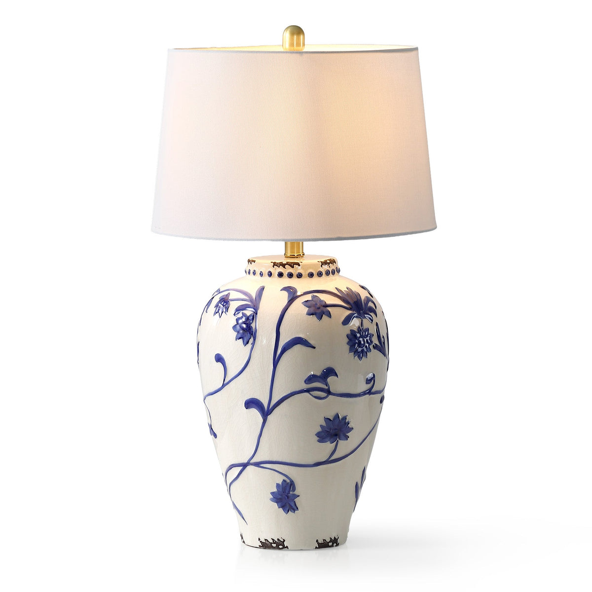Blue and white porcelain table lamp with cream burlap shade, shown from front angle