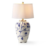 Blue and white porcelain table lamp with cream burlap shade, shown from front angle