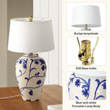Blue-and-white porcelain table lamp with burlap shade on wooden surface